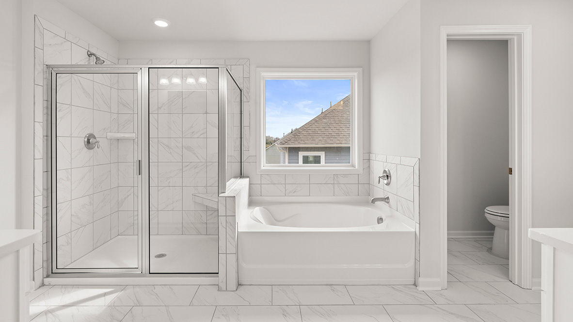 Interior primary bathroom with shower and bath tub