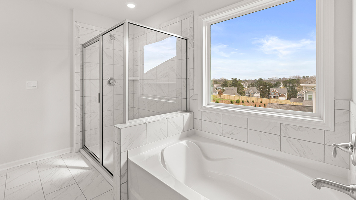Interior primary bathroom with shower and bath tub