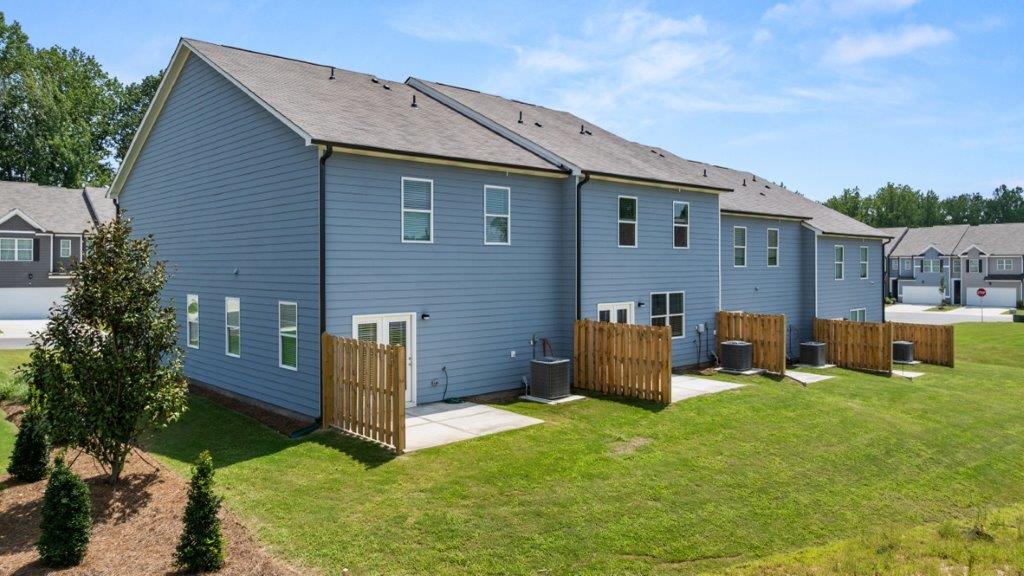 Rear view of townhomes highlighting outdoor living and building layout Hughes Court