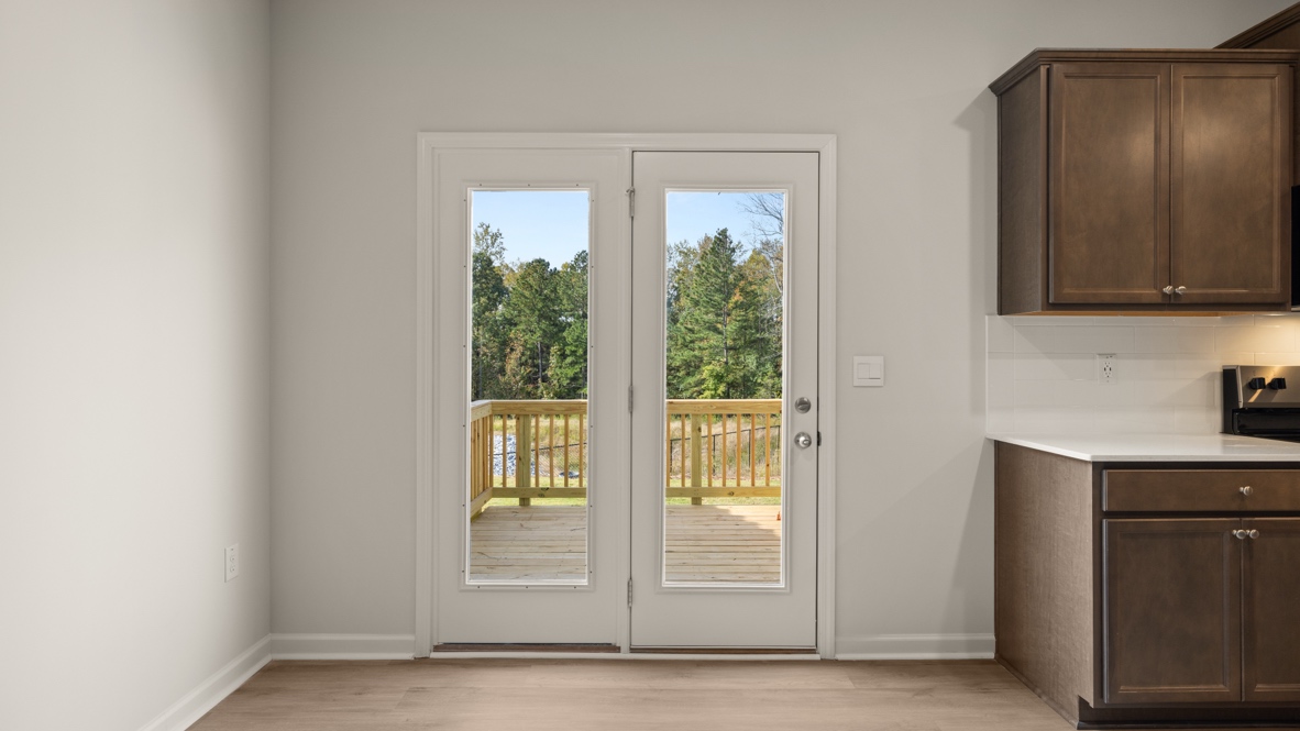 Interior dining area next to back patio doors and wooden cabinets