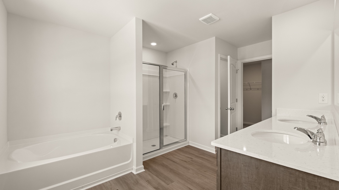 Interior primary bathroom with double sink, bath tub and shower