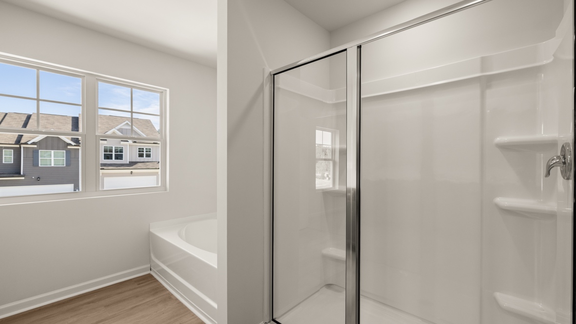 Interior primary bathroom with bath tub and shower