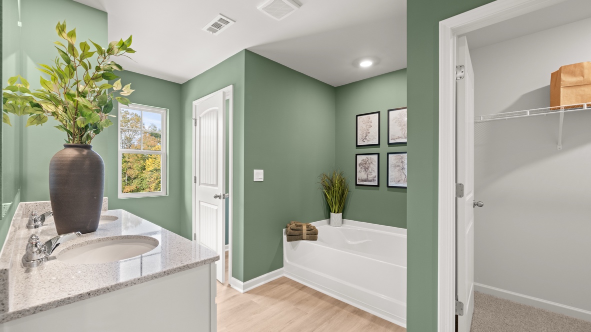 Interior primary bathroom with double sink and bath tub