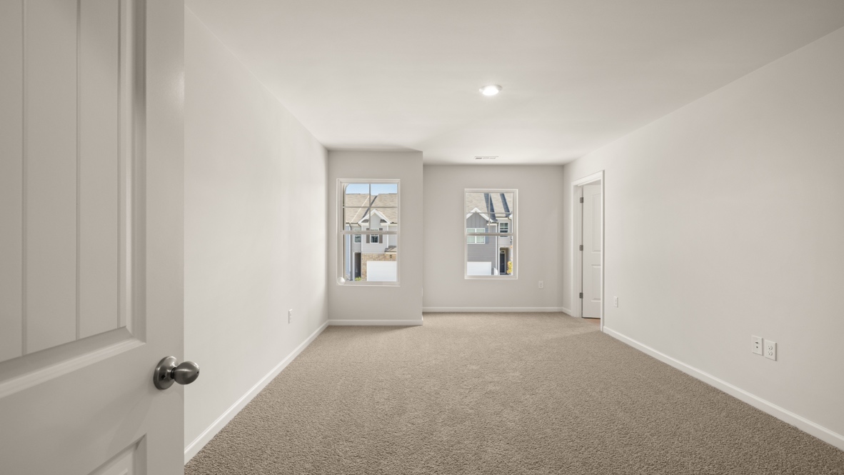 Interior primary bedroom with large windows