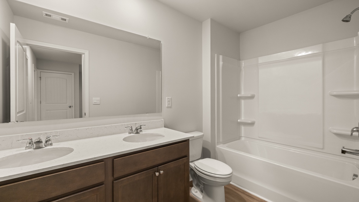 Interior bathroom with double sink and full-sized shower
