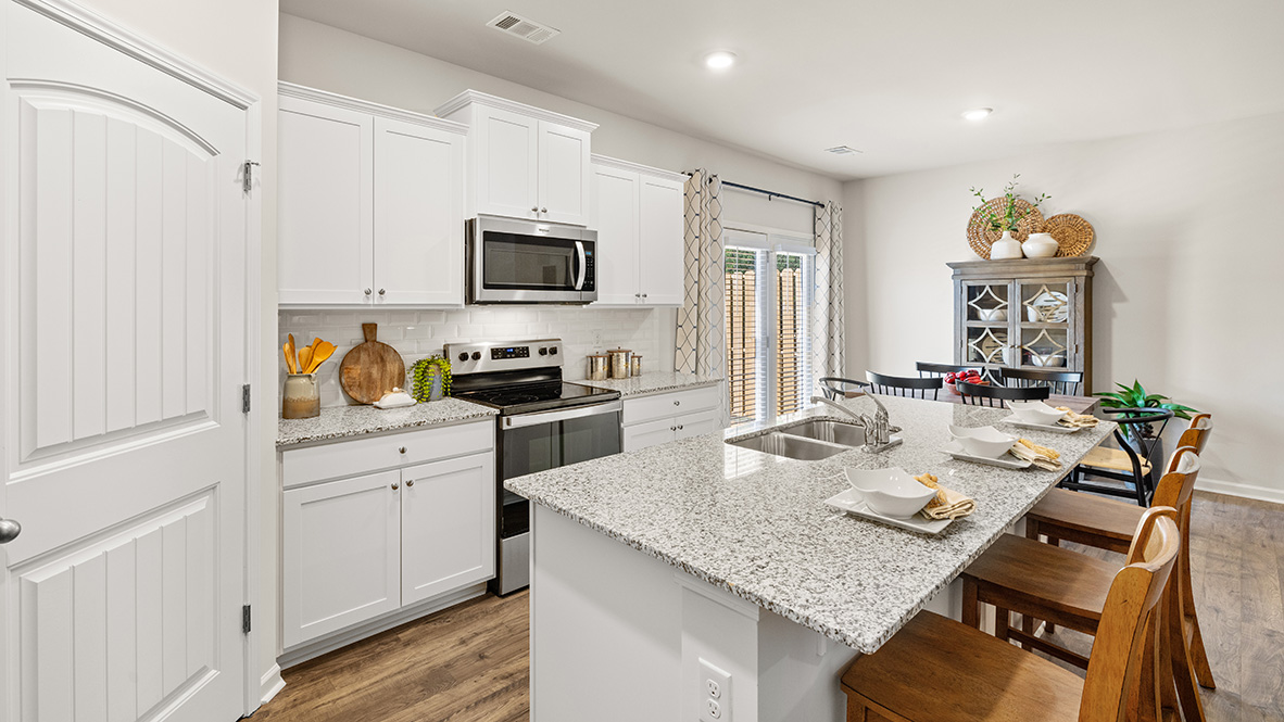 Interior kitchen with center island and white cabinets