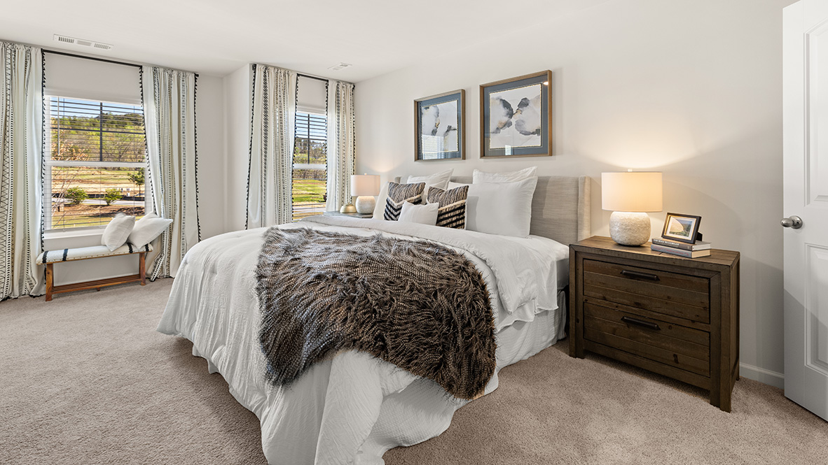 Interior primary bedroom with large windows
