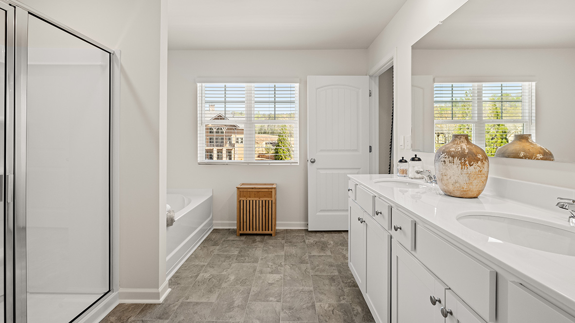 Interior primary bathroom with double sink, shower and bath tub