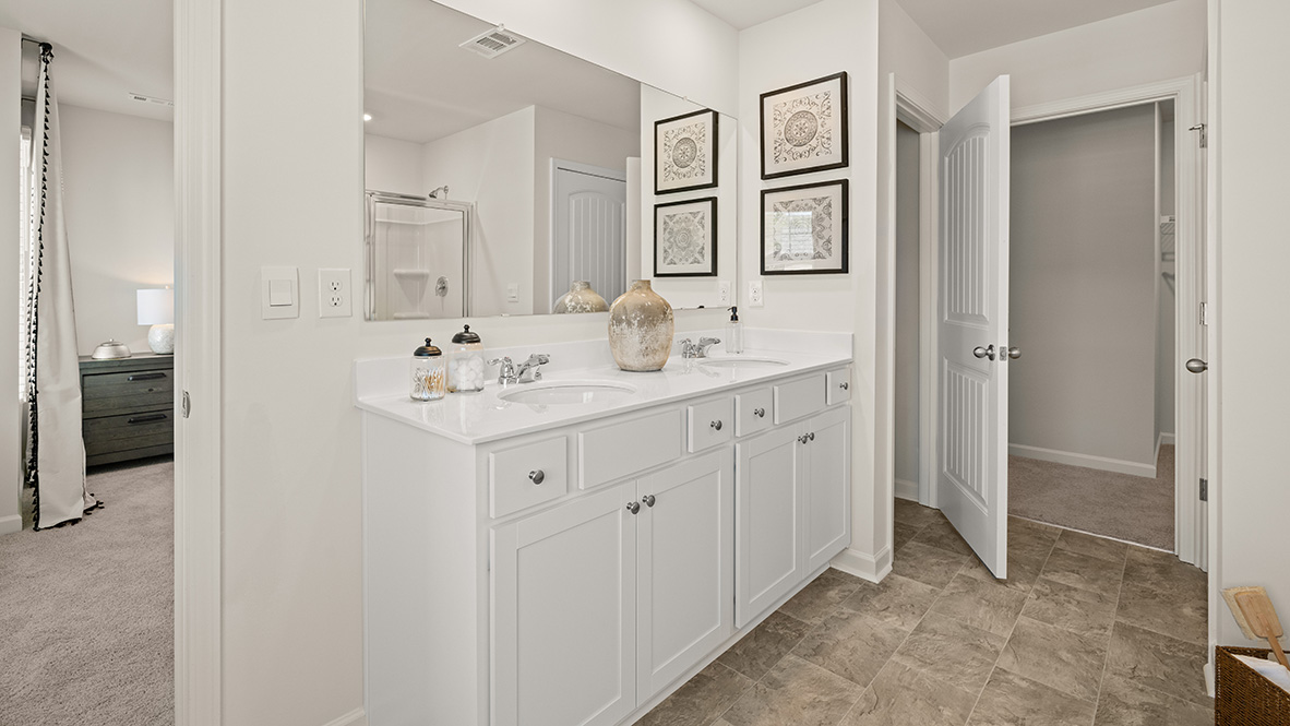 Interior primary bathroom with double sink, shower and bath tub