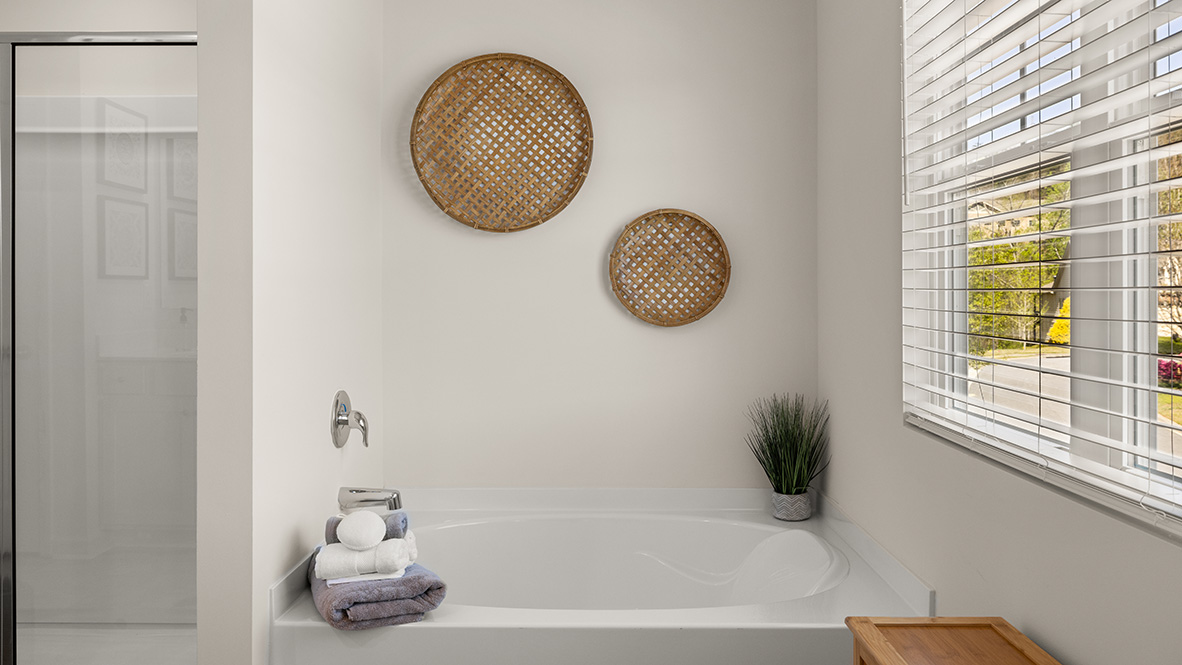 Interior primary bathroom with double sink, shower and bath tub