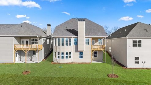 Rear exterior of two-story home with double height bow windows Lake Lanier D.R. Horton