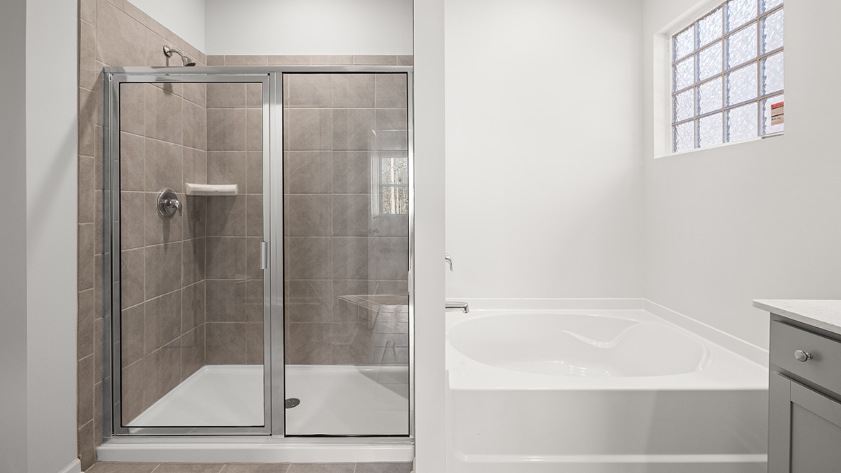 Interior primary bathroom with shower and bath tub