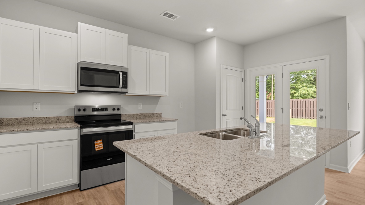 Interior kitchen with center island and white cabinets