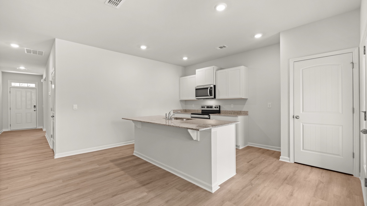 Interior kitchen with center island and white cabinets