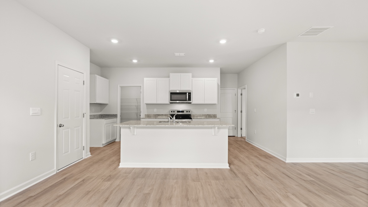 Interior kitchen with center island and white cabinets