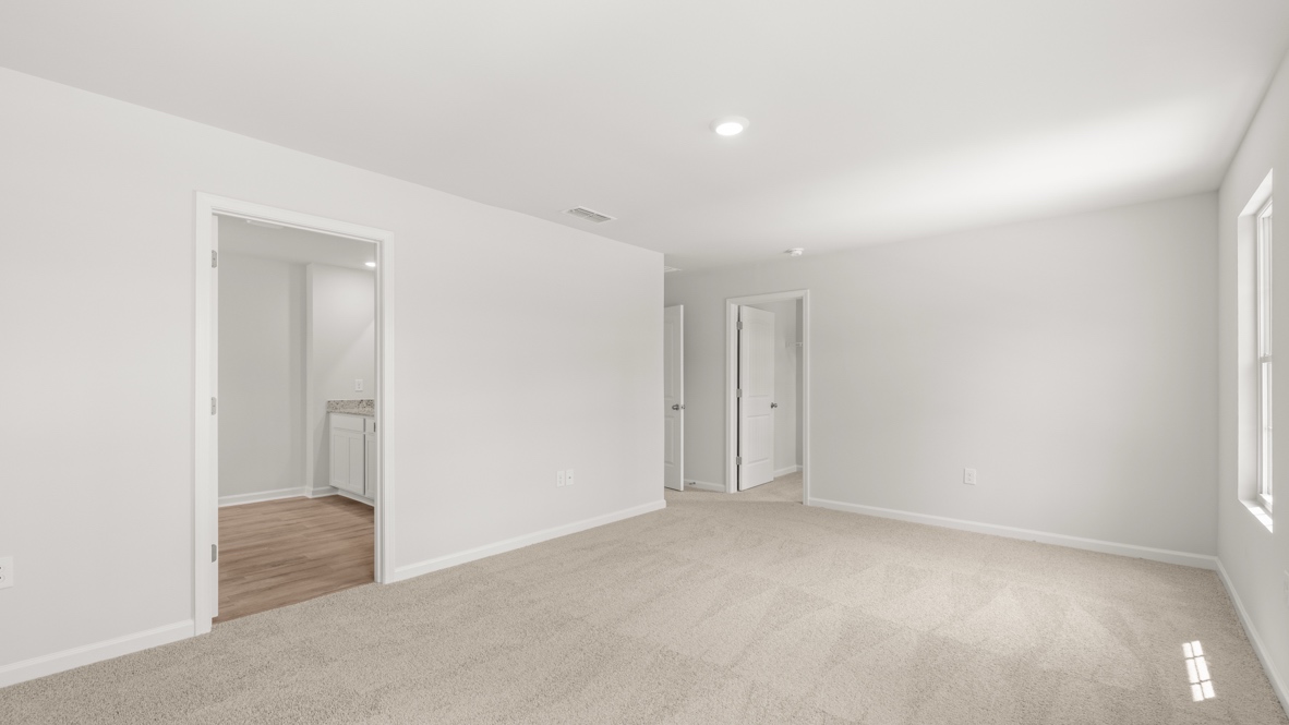 Interior primary bedroom with large windows