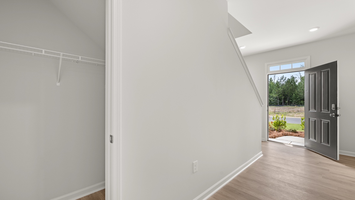 Interior entry-way open to staircase and leading to living area