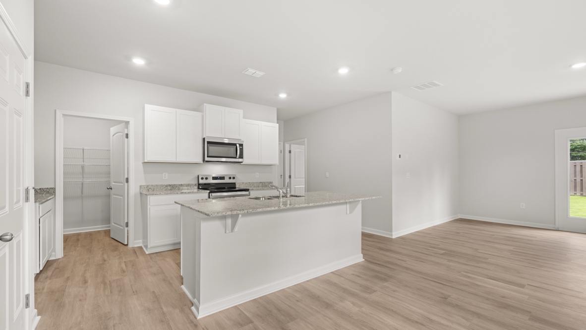 Interior kitchen with center island and white cabinets