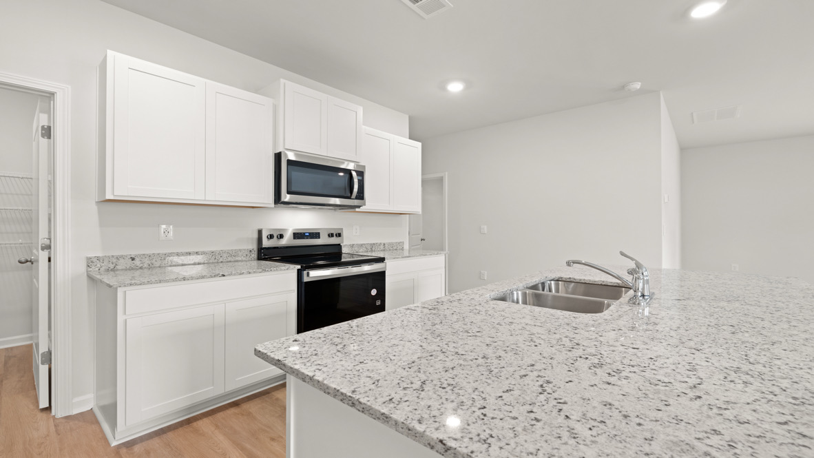 Interior kitchen with center island and white cabinets