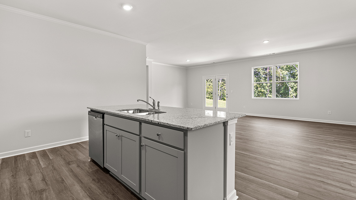 Interior kitchen with center island open to living area with large windows