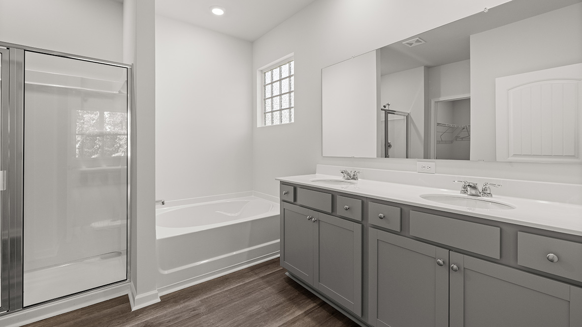 Interior primary bathroom with double sink, shower and bath tub