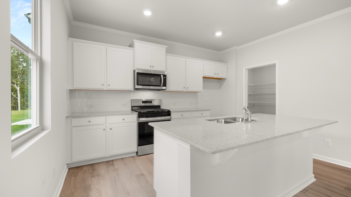 Interior kitchen with center island and white cabinets