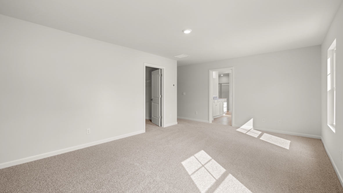 Interior primary bedroom with large windows