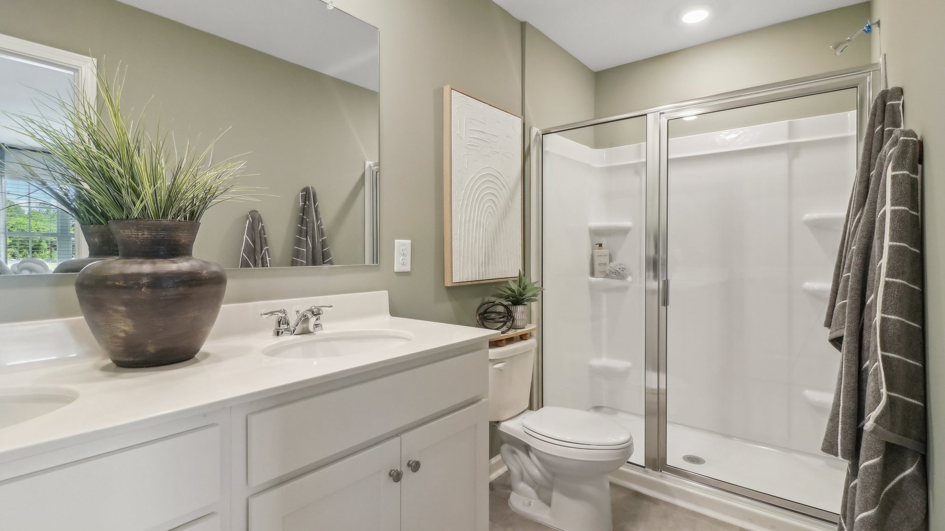 bathroom with white finishes, dual sinks and a walk in shower