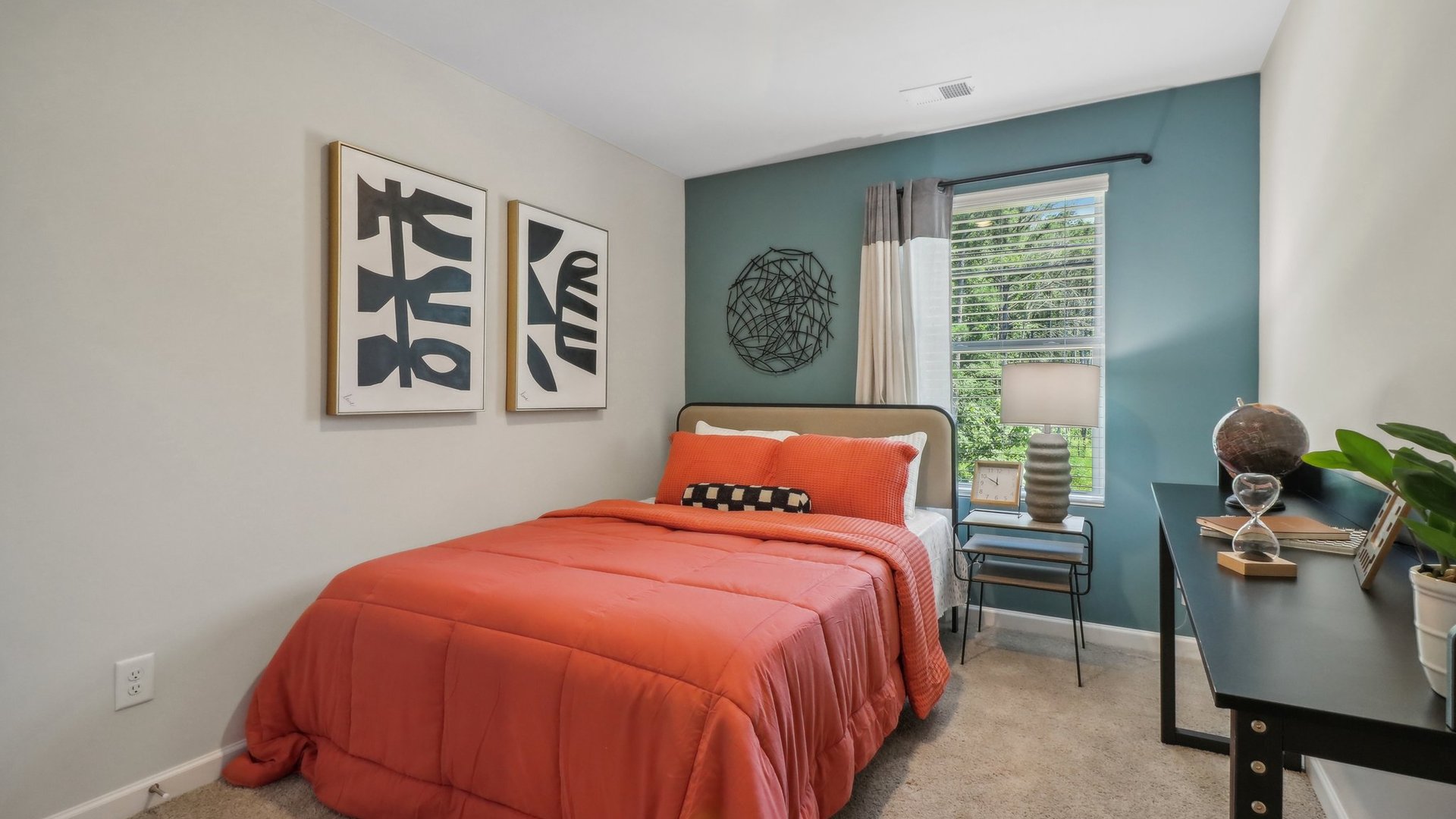 bedroom with a teal accent wall, and orange bedding