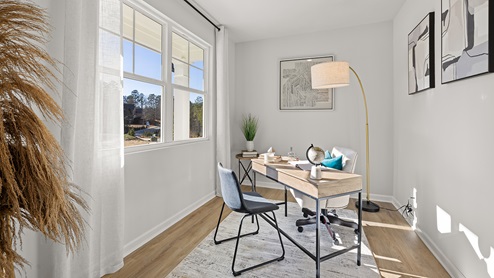 A bedroom with windows, used as an office space.