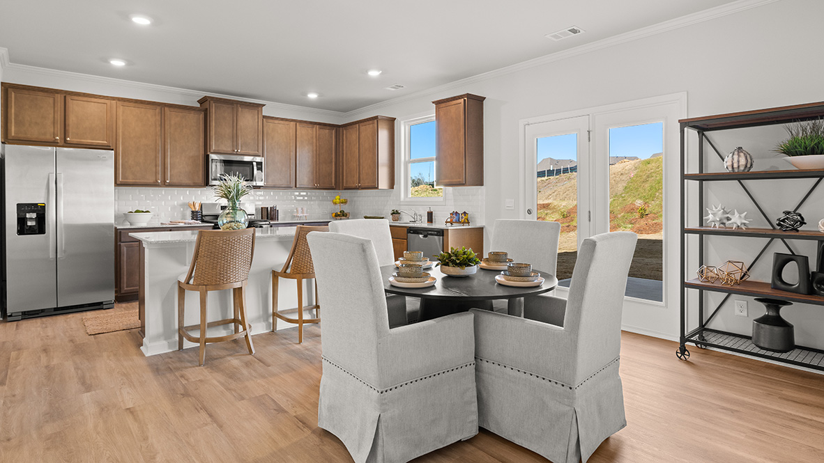 Breakfast nook with white countertops, white tile backsplash and brown shaker cabinets.