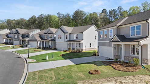 Multiple two-story elevations with white and gray siding, white trim, brick details and green lawns.
