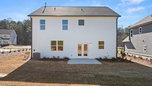 Exterior image of back of house with white siding and black roof.