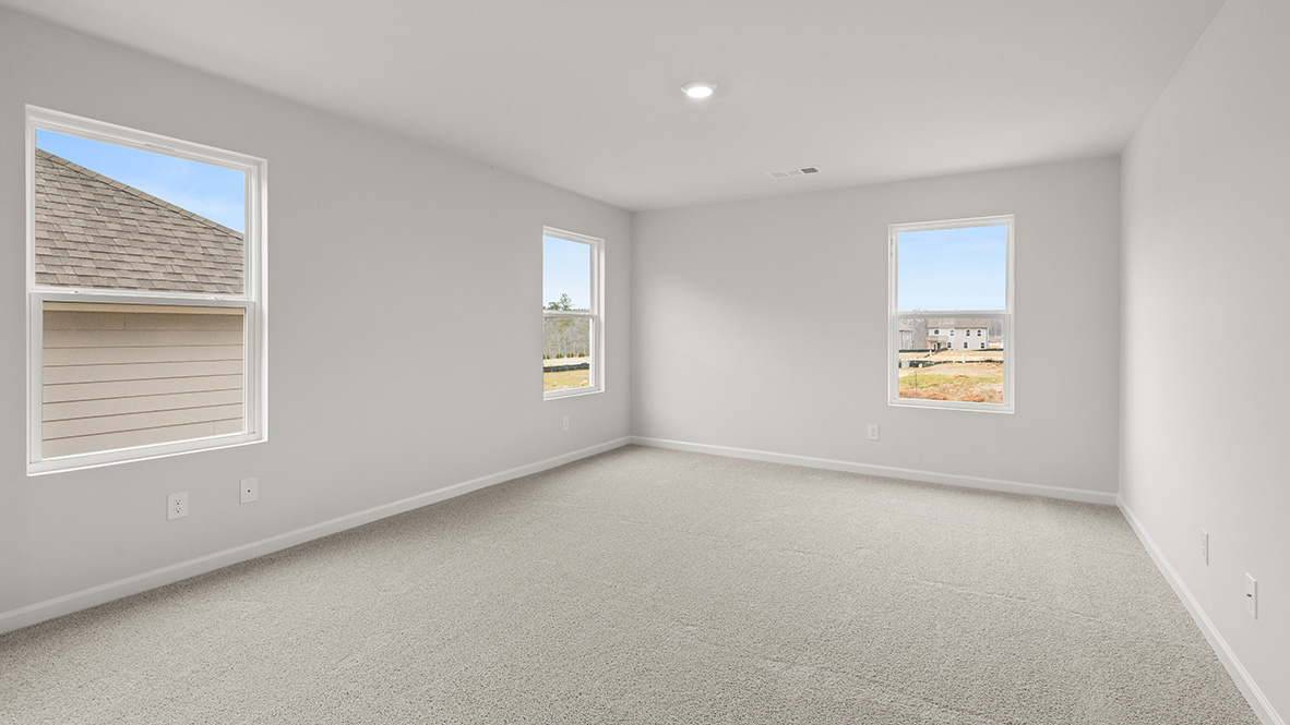 Interior primary bedroom with large windows