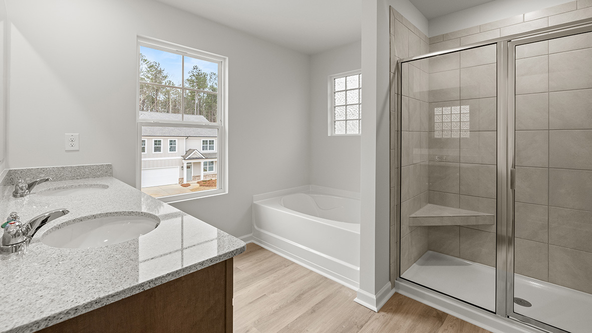 Interior primary bathroom with double sink, bath tub and shower