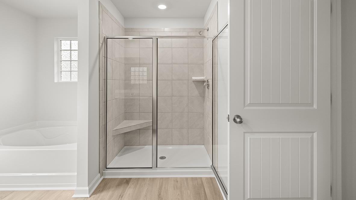Interior primary bathroom with bath tub and shower