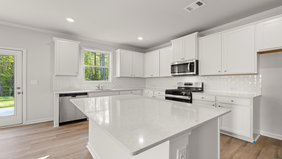 Interior kitchen with center island and white cabinets