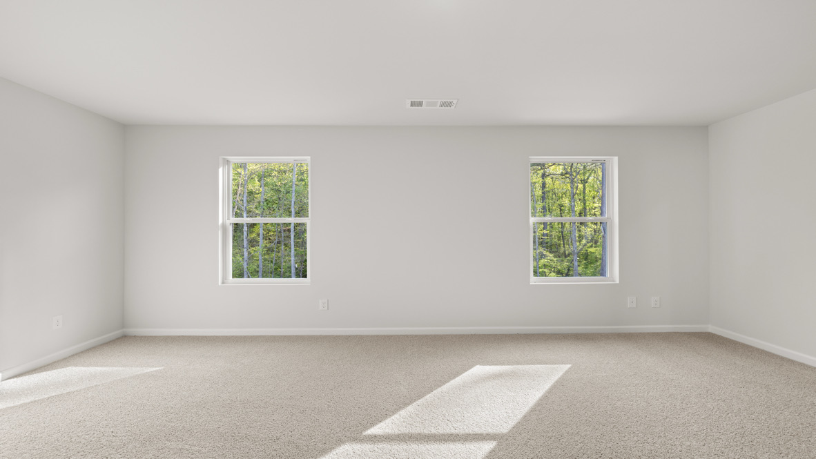 Interior primary bedroom with large windows