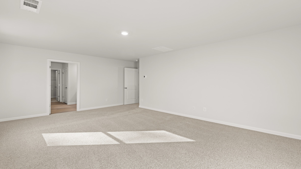 Interior primary bedroom with large windows