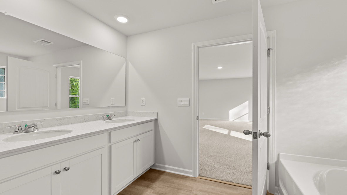 Interior primary bathroom with double sink, shower and bath tub