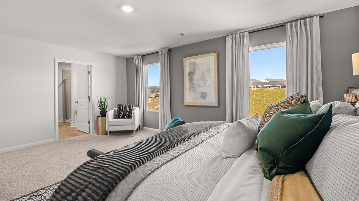 Interior primary bedroom with two large windows and accent wall