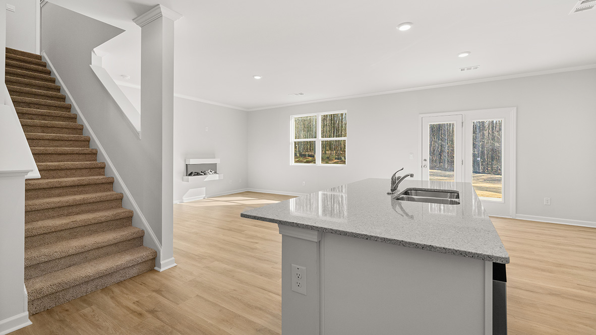 Interior kitchen with center island open to living area and staircase