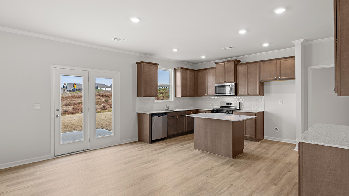 Interior living area open to kitchen with center island and wooden cabinets