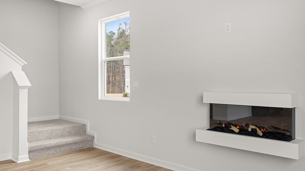 Interior living area with staircase next to window and fire place