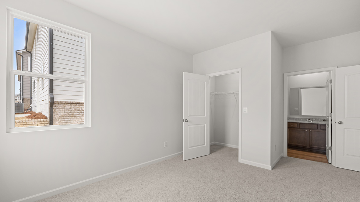 Interior bedroom with large window, closet and bathroom