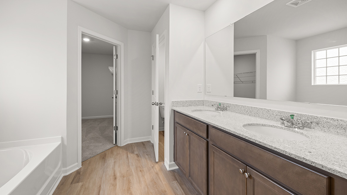 Interior primary bathroom with double sink and bathtub