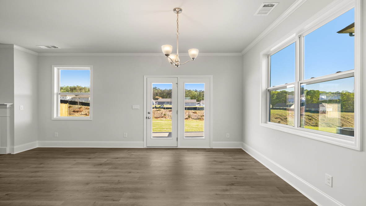 Kitchen-family room combo in this New Home includes Modern Design elements like wide sightlines, durable flooring, and natural lighting throughout.