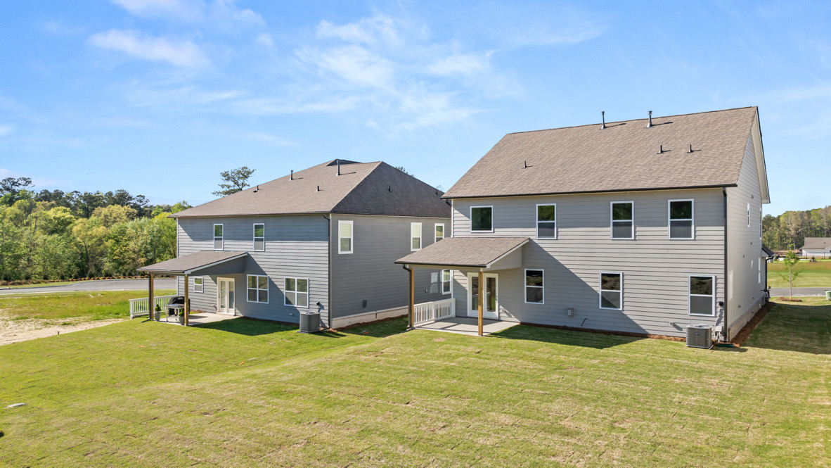 Backyard image of New Homes in Hamptons at Riverwood showing multiple D.R. Horton designs with and back patio and green grass
