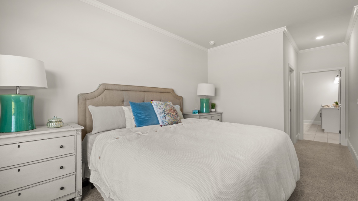 Primary bedroom with door to living area and door to primary bathroom.
