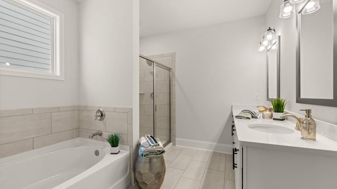 Primary bathroom with double sinks and white cabinets.
